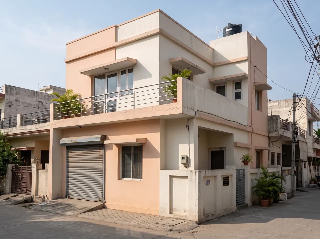 Normal Indian house elevation in peach with steel balcony railing and garage shutter