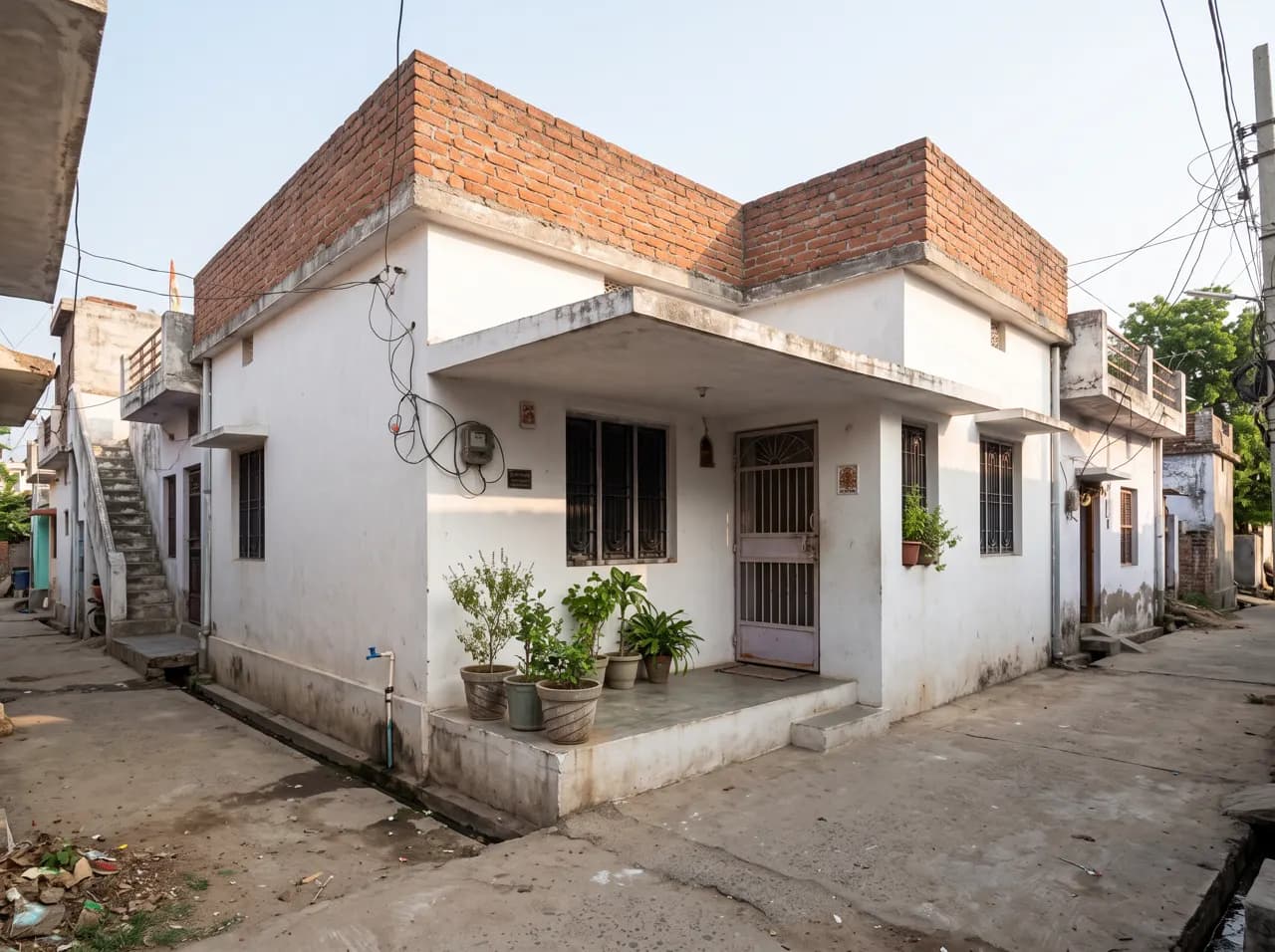 Budget house front with exposed brick parapet, white walls and simple porch