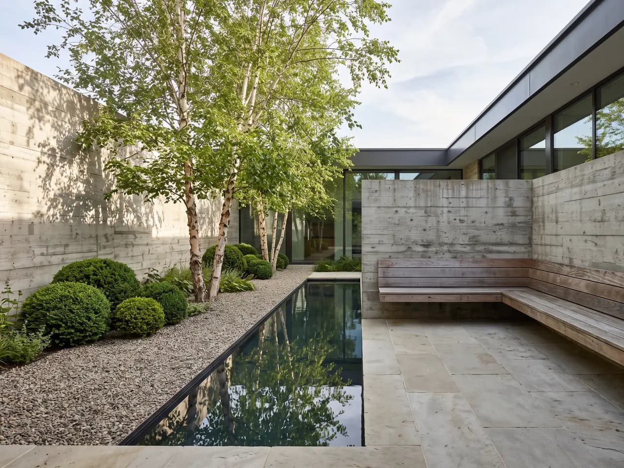 Contemporary courtyard garden design with reflecting pool, birch trees and limestone paving